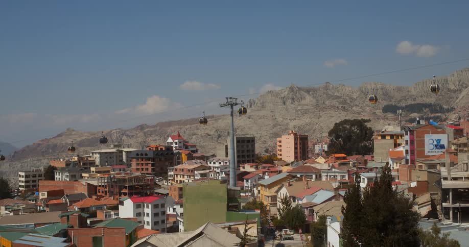 A gondola moves over apartment buildings in a city