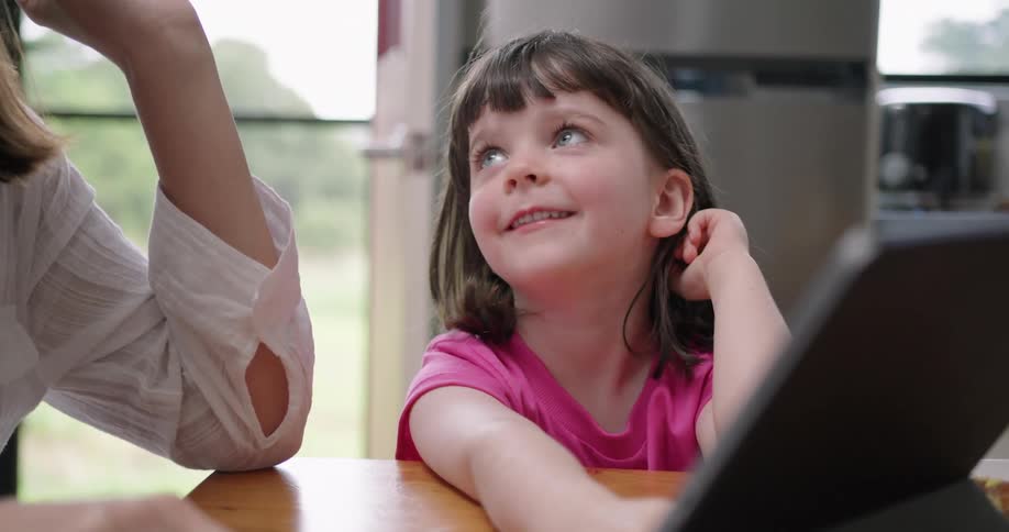 A mother and daughter looking at a tablet