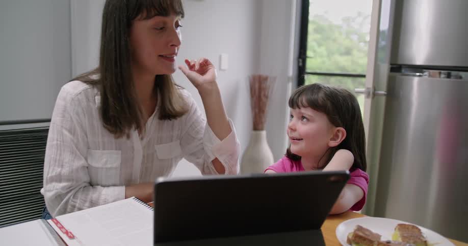 A mother and daughter sitting around using a tablet