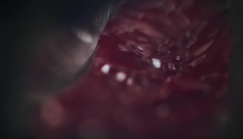 A thick red liquid is poured into a metal mixing bowl