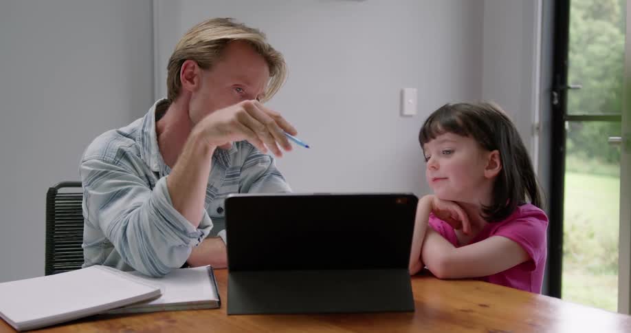 A man and girl talk while looking at a laptop