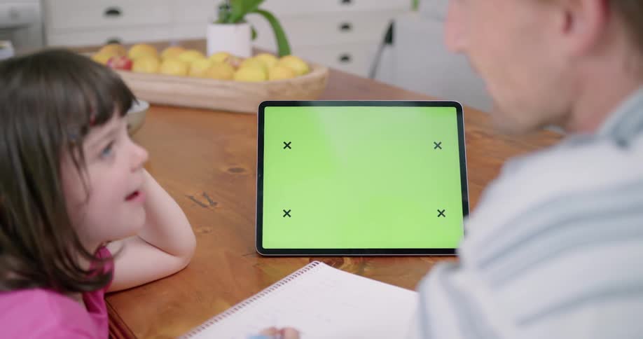 A man and girl talk and look at a tablet