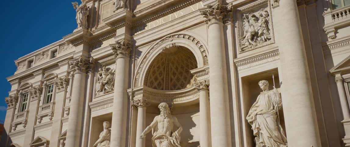 A view of a building with statues out front of it