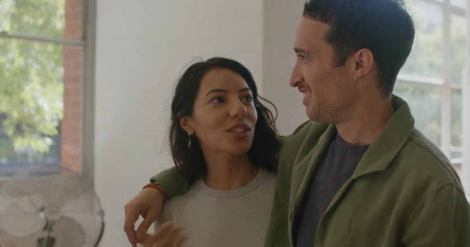 A man and two women talking in a house