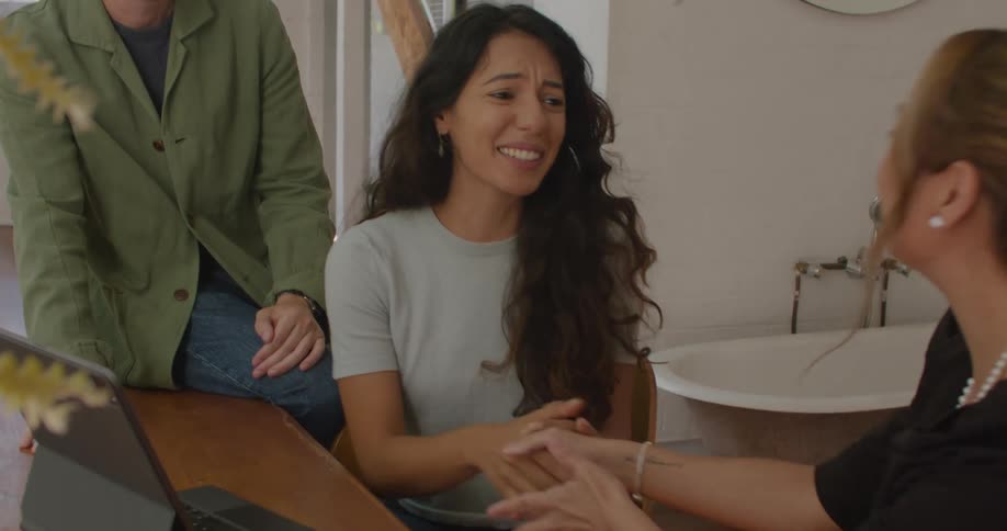 A couple smile and gratefully shake the hand of their realtor