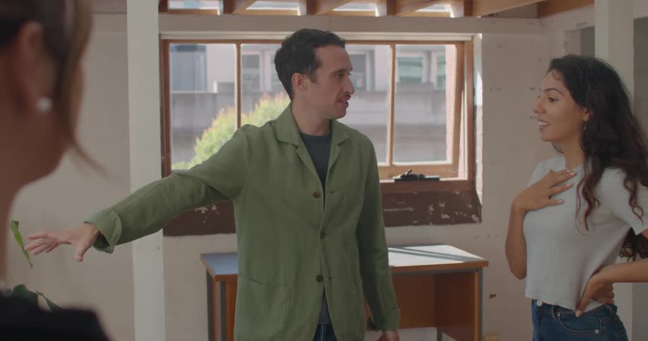 A couple discuss the space and possible renovations while looking at an apartment with a realtor