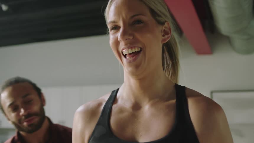 A woman is working out with her trainer indoors