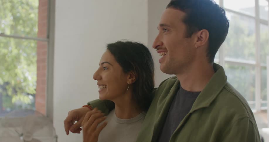 A man and woman talk and point around the house