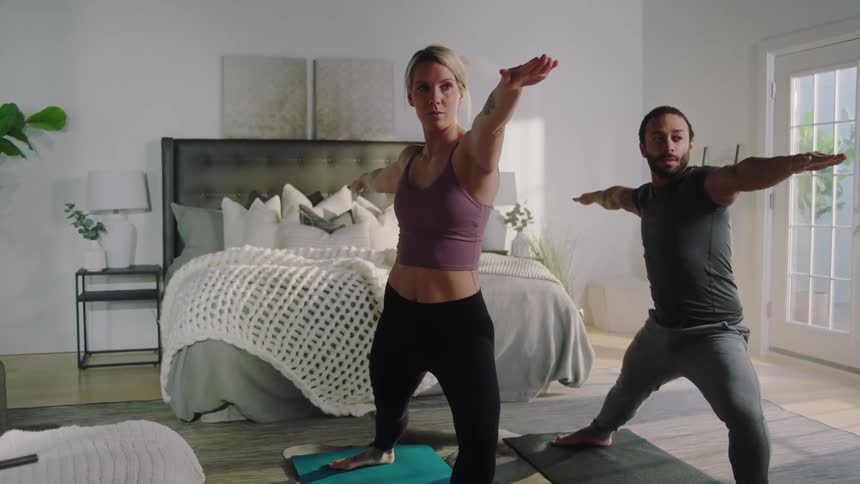 A man and woman doing yoga in a room