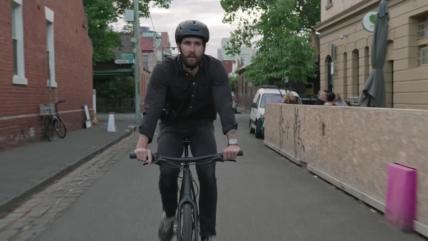 A man rides his bicycle through the town