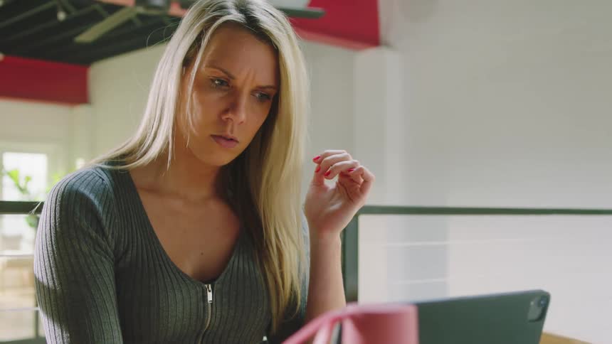 Blonde woman with green shirt uses tablet