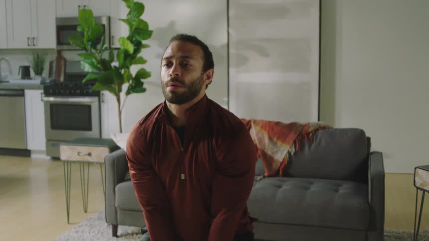 A man lifts a kettle ball in his living room