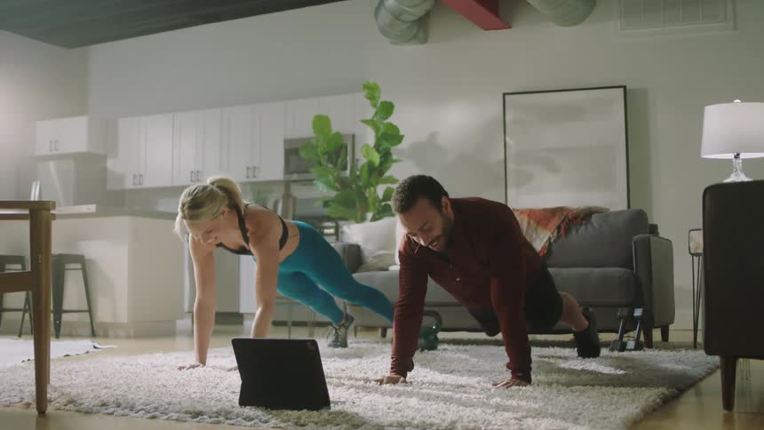 A man and woman exercising in a room