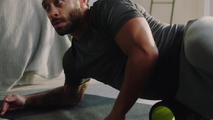 A man working out on an exercise roller in a bedroom