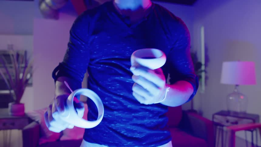A man is playing a virtual reality game in his living room