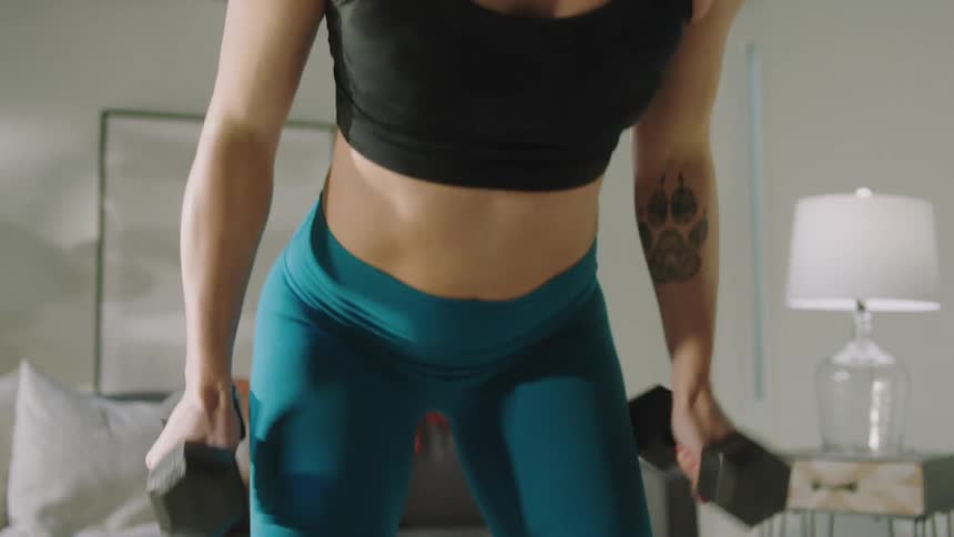 A woman is lifting weights at home