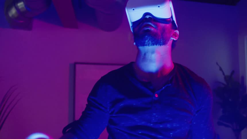 A man wearing a virtual reality headset in a dark living room