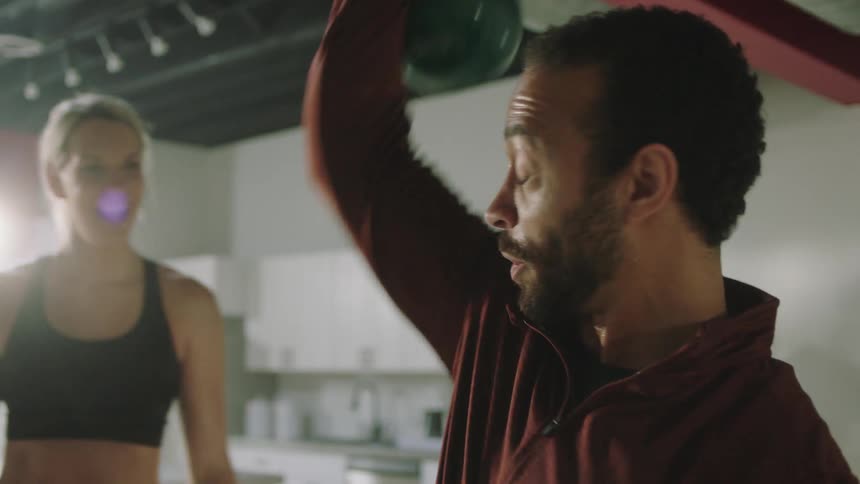 A man is lifting a kettle bell above his head
