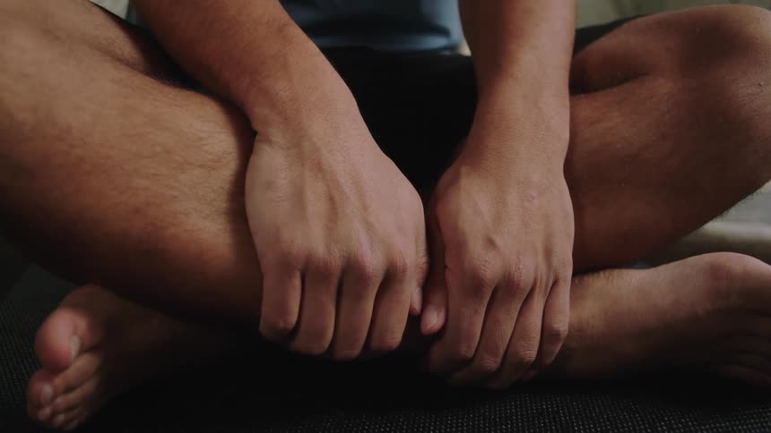 A man meditating on the floor of a room