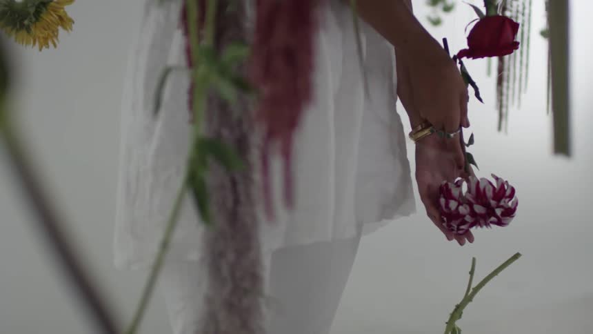 Woman standing and holding flowers upside down