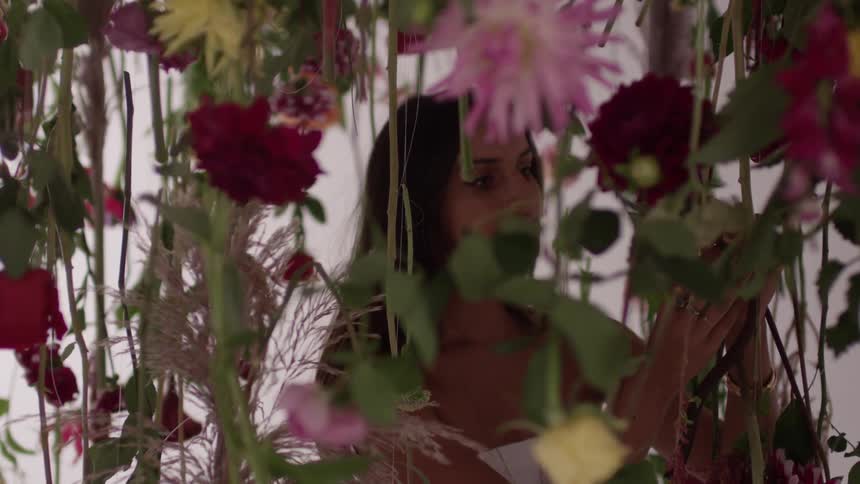 Woman admiring some hanging flowers