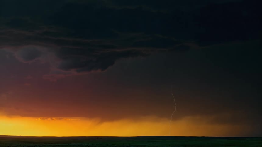 Lightning flashes and the sky glows orange during a storm