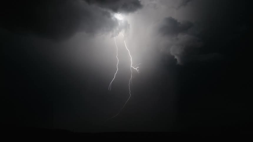 Flashes of lightning light up the dark sky