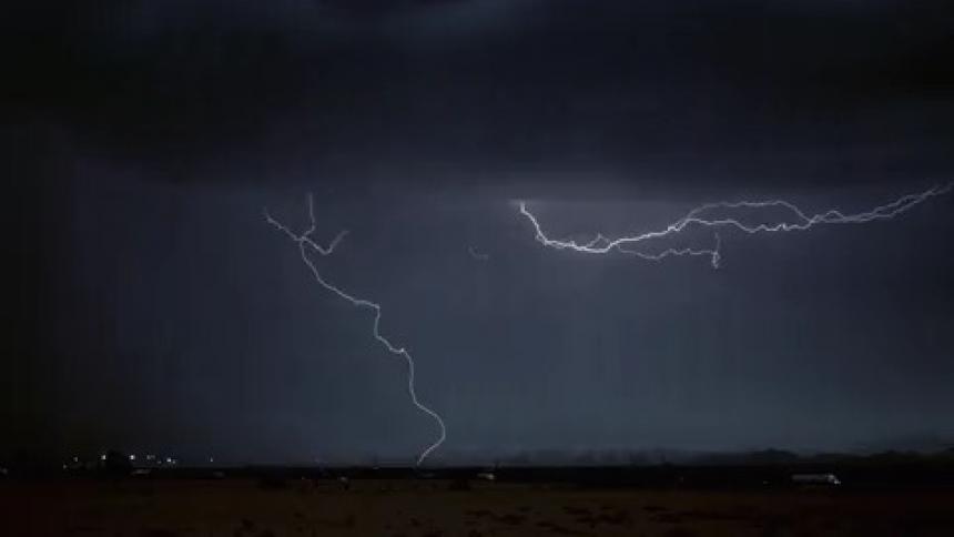 A storm is forming in the sky in a rural area