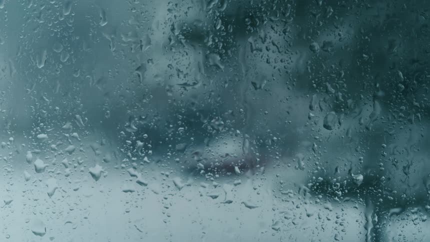 Falling rain and sleet frost up a glass window