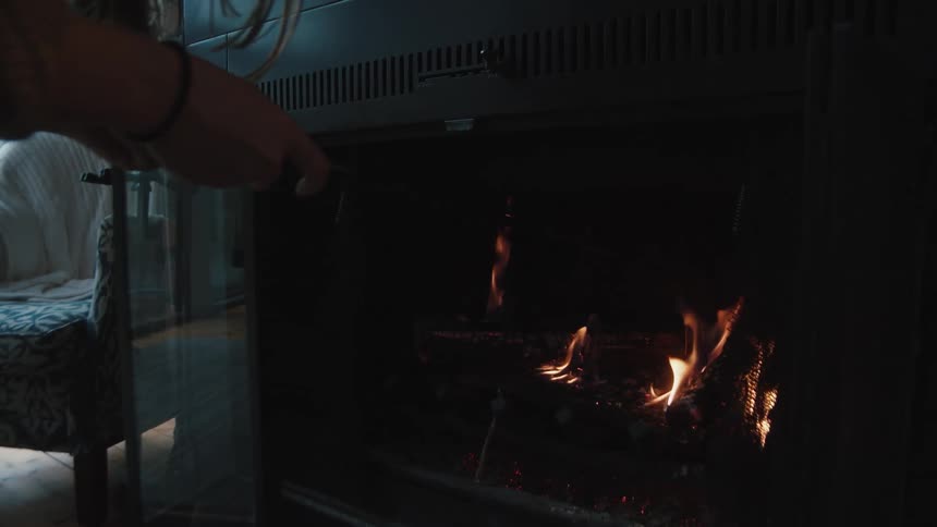 A person is near a fireplace inside of their house