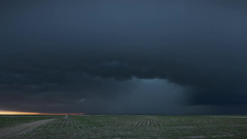 Storm clouds floating over a rural field at sunset