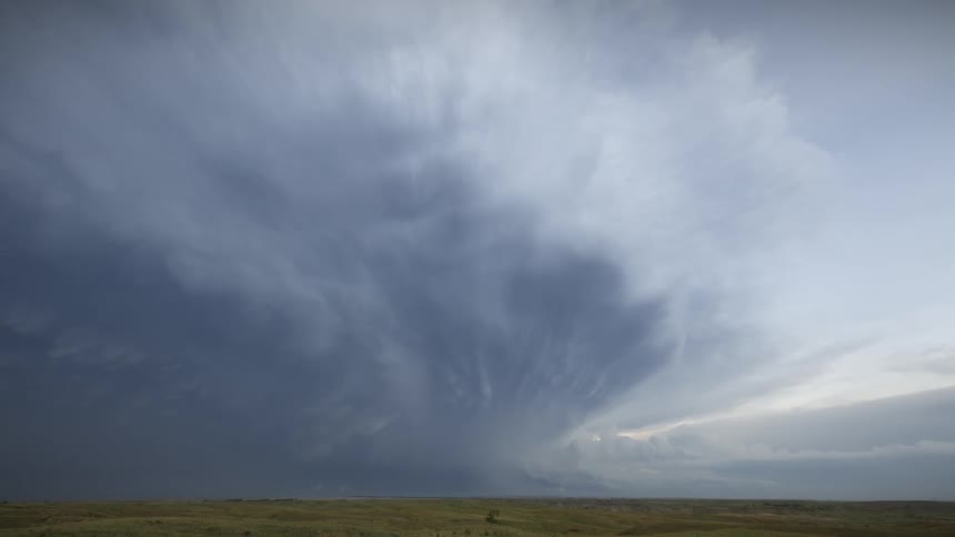 Off on the horizon dark grey storm clouds gather with lightnings