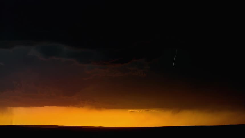 Dark clouds over a grassland with a flash of lightning