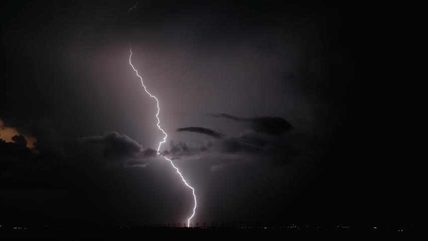 Lightning is flashing in the sky during a storm at night