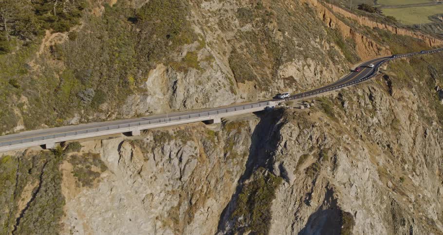 Vehicles drive across a mountain road