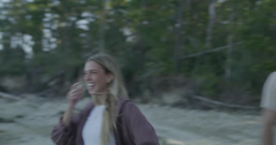 A teenage boy and girl laugh on the beach