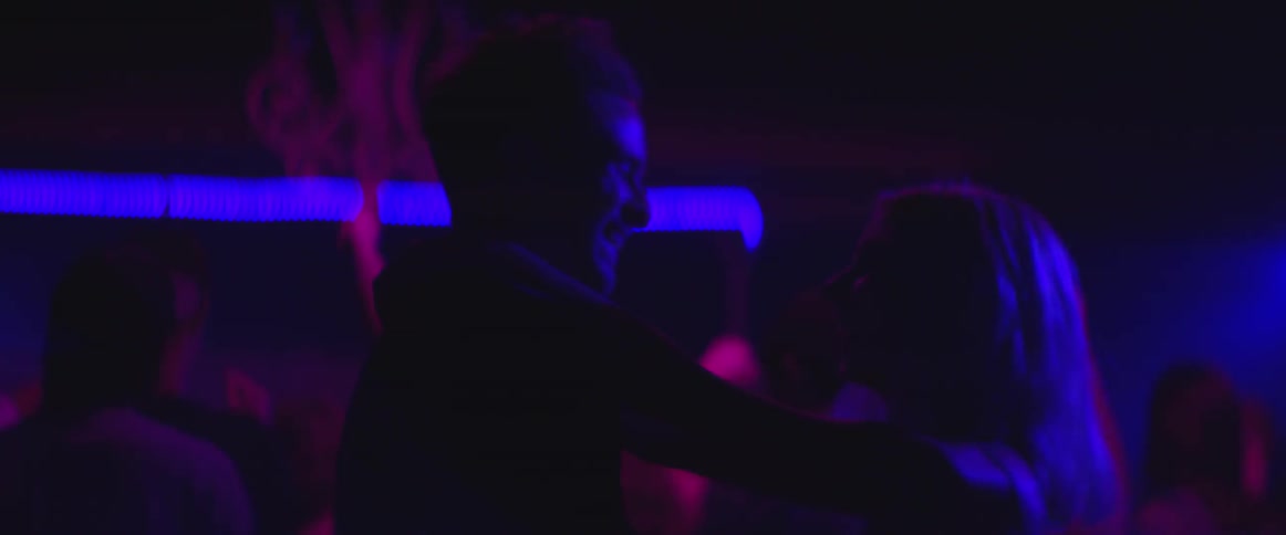 People are dancing in a dark club