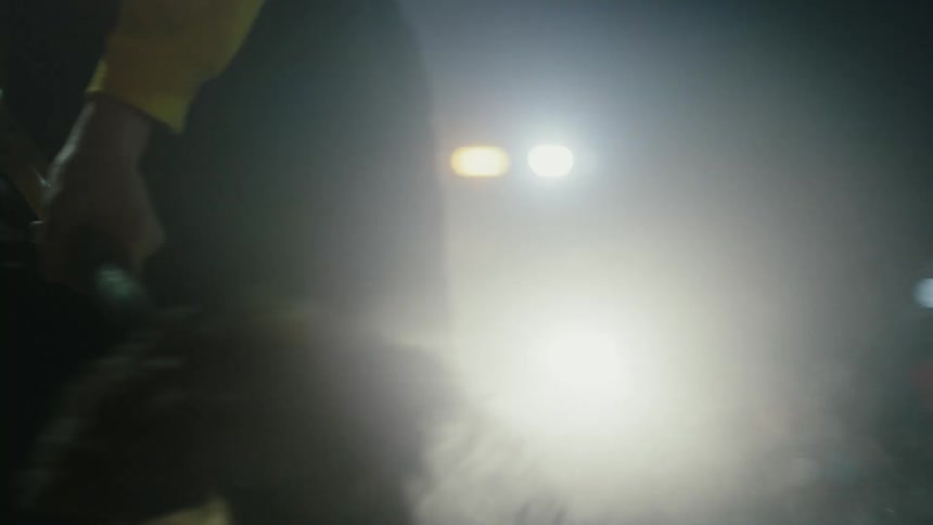 A construction worker is shoveling dirt at night
