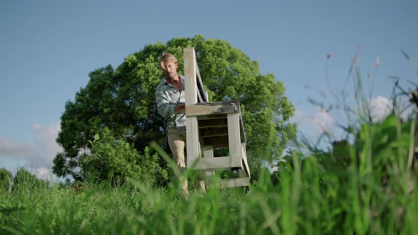 Man is moving an a bench outdoors in spring