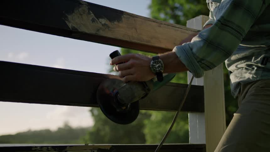 A man working on a fence with a tool