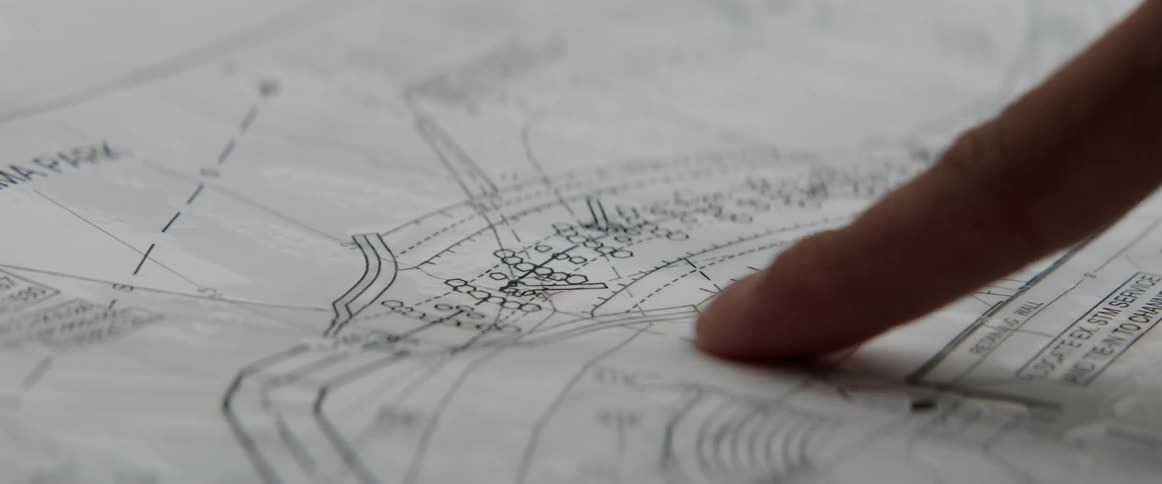 A man is pointing at blueprints