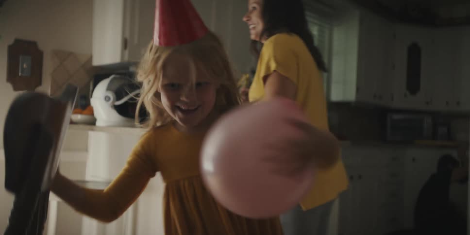A child runs around with a balloon at a birthday party