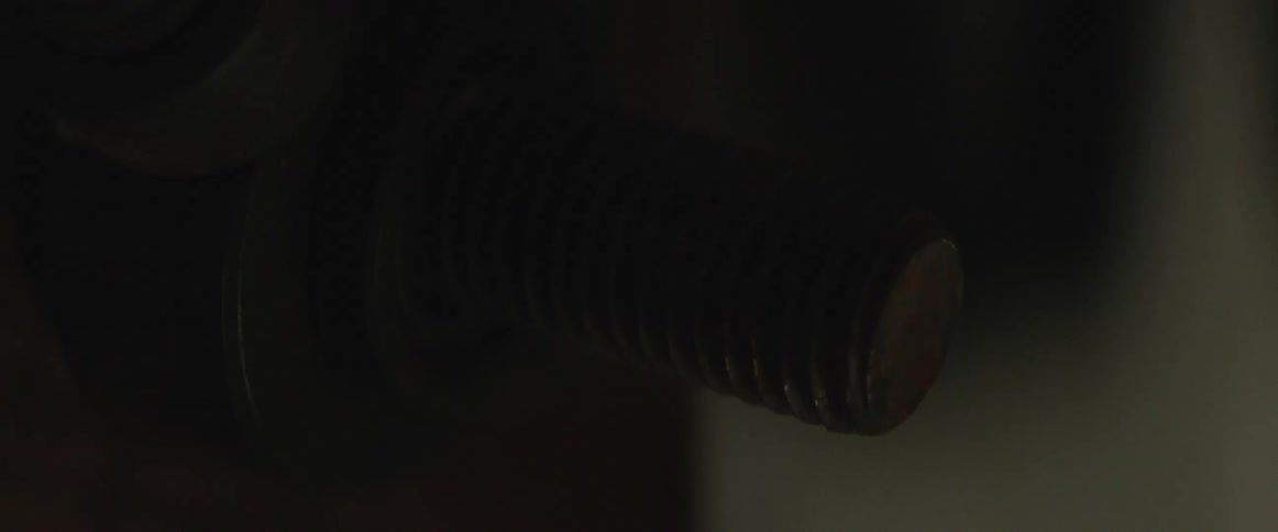 A metal screw in darkness