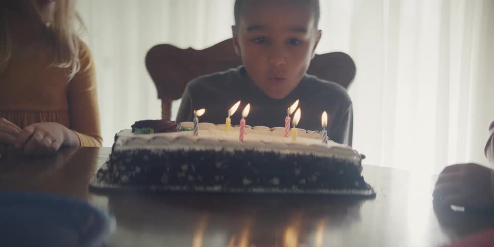 A child blowing out candles on a cake
