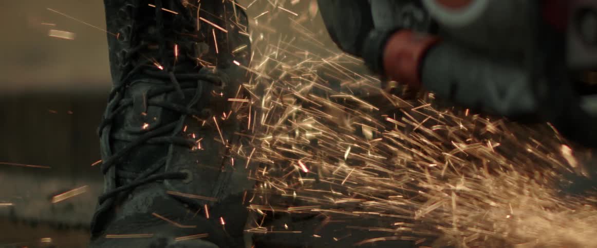 A construction worker grinding metal