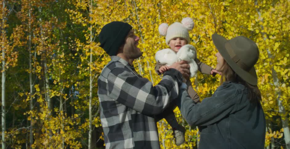 A mother hands her son to the father