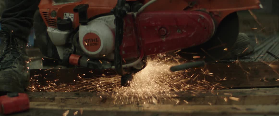 Sparks flying around a power saw cutting through metal