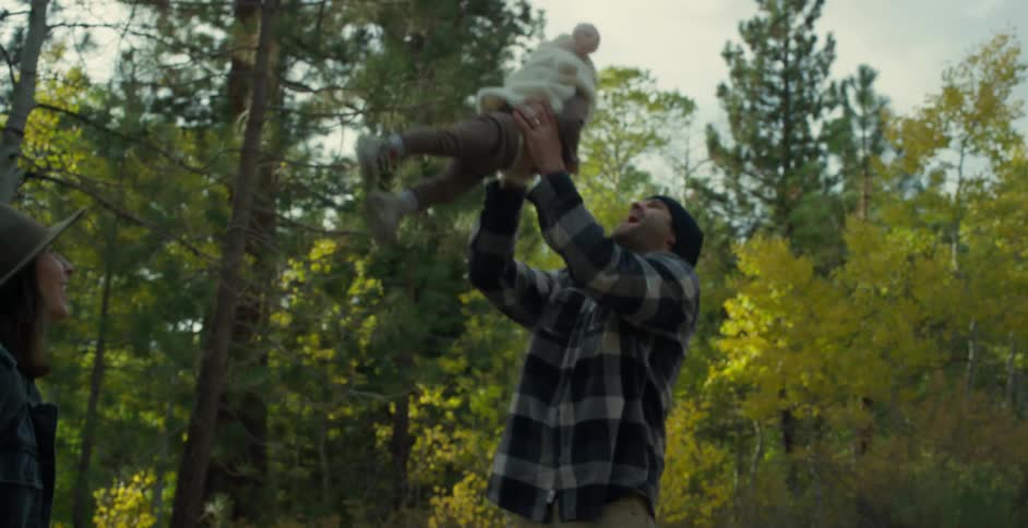Parents playing with their toddlers on a rural road near a forest in the morning