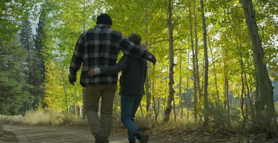 Husband and wife are hiking with their child in a wooded area