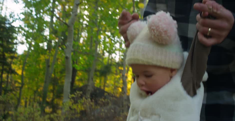Father helps daughter to walk down a fallen tree in the forest at morning